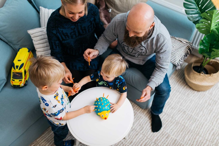 Perhe pelaa yhdessä vuokra-asunnon olohuoneessa