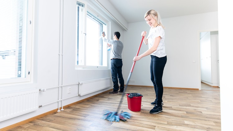 Mies ja nainen siivoavat vuokra-asuntoa