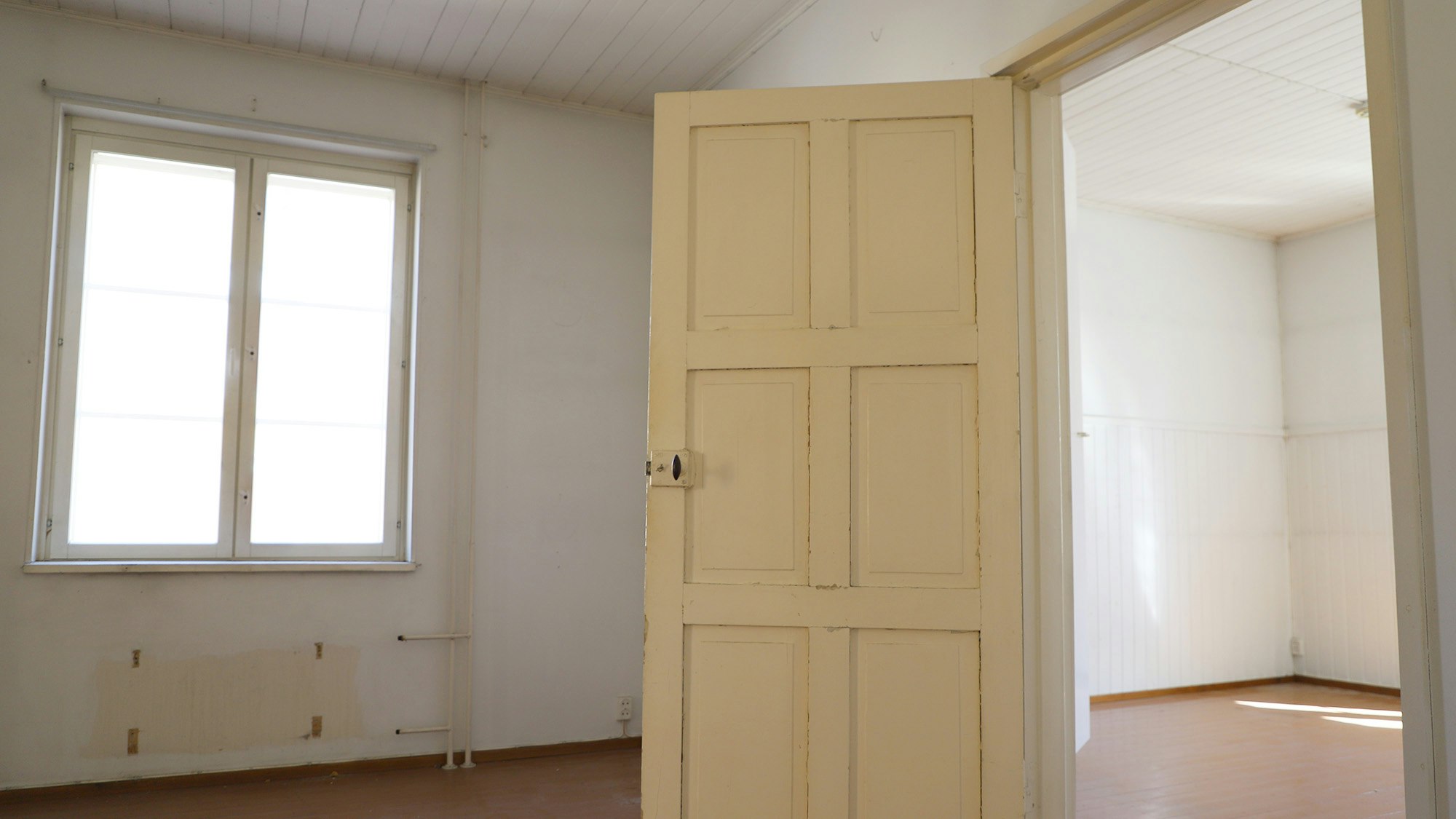 Kuvassa asunnon sisäpintoja ennen remonttia, kuvassa keskellä vanha väliovi.