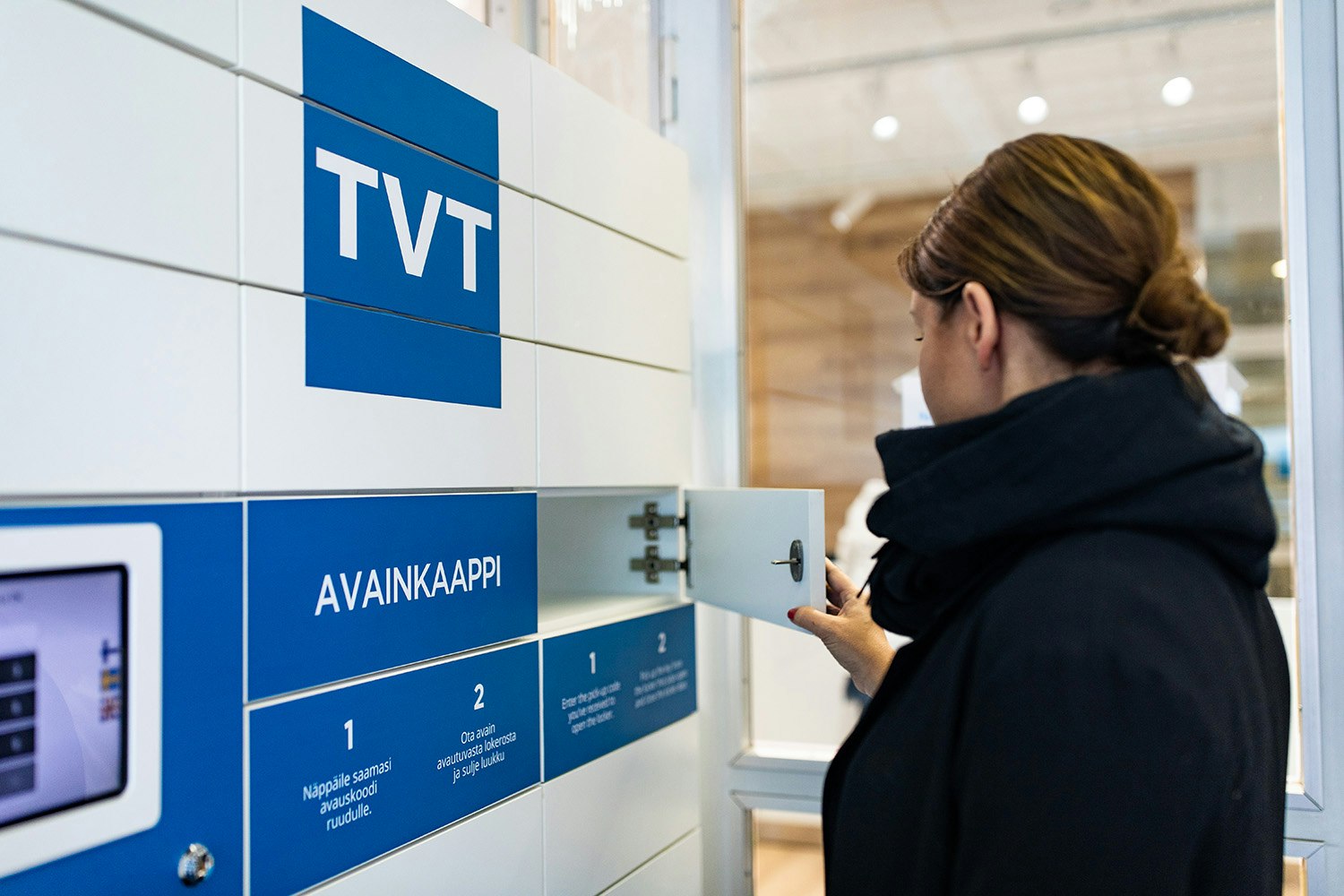 Asukas hakemassa avaimia avainkaapista.