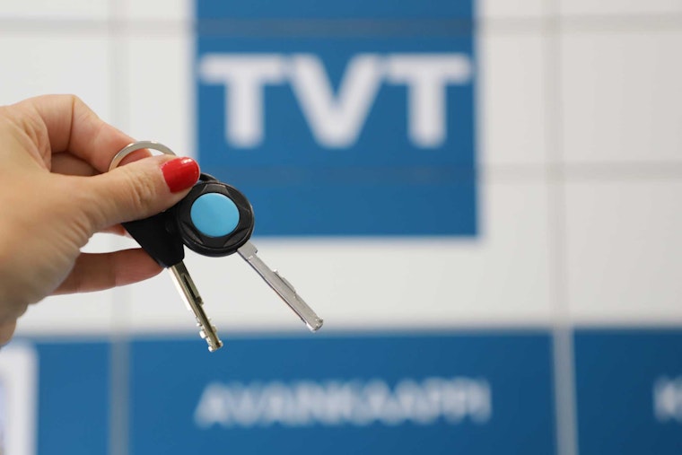 Avaimet kädessä. Taustalla TVT:n logo.