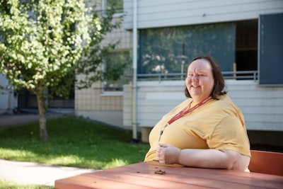 Ulla Auvinen istumassa kotipihallaan.