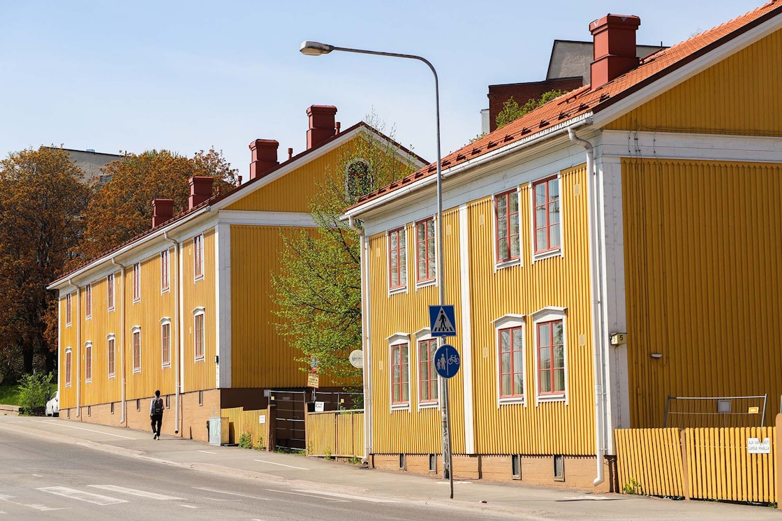 Kaksi keltaista puutaloa, joiden edestä kulkee kävelytie.