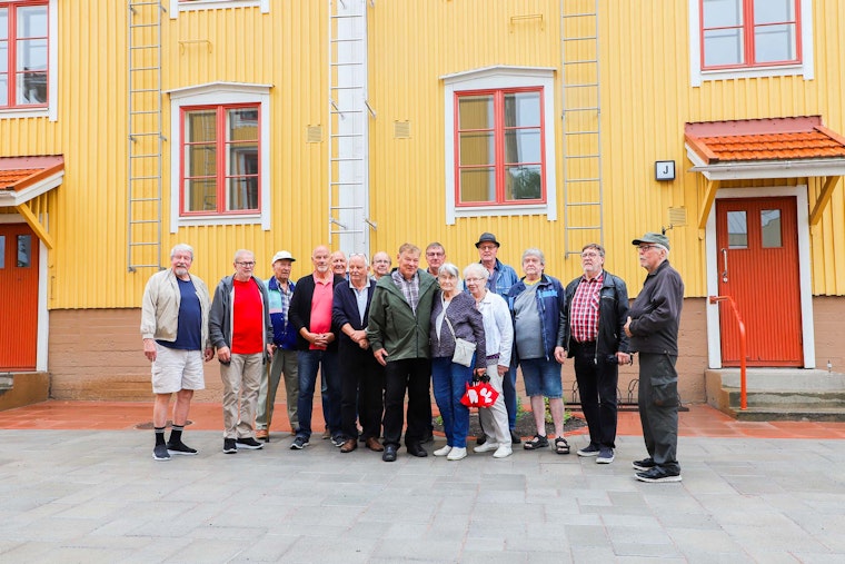 Lapsuus- ja nuoruusvuotensa Köydenpunojankatu 5:ssä asuneet tutustumiskäynnillä. Ryhmän taustalla keltainen puutalo, jossa punaiset ikkunanpuitteet ja punaiset ulko-ovet.