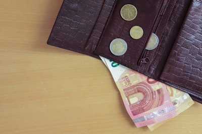 Ruskea lompakko, jossa kolikoita ja seteleitä.