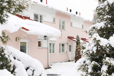 Lunta talon katolla ja puiden oksilla.
