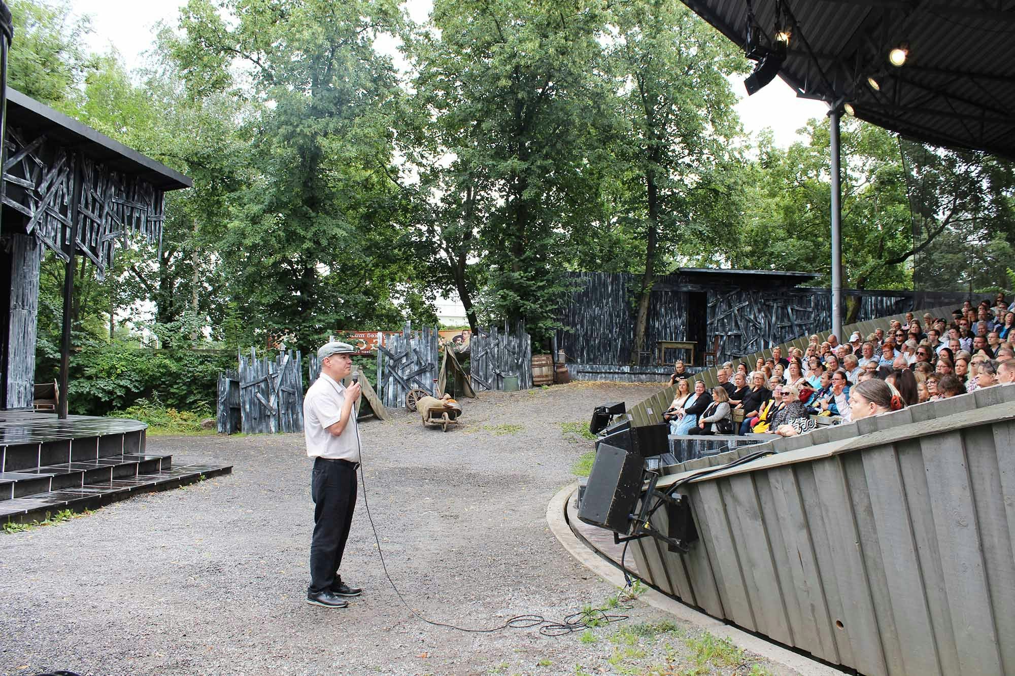 Teppo Forss pitää puhetta asukkaille teatterin lavalla.