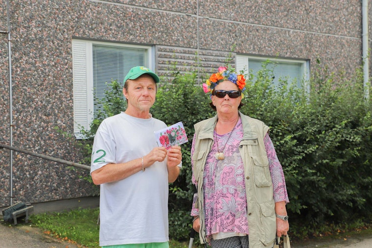 Kaksi henkilöä, joista toisella on kukkaseppele päässään.