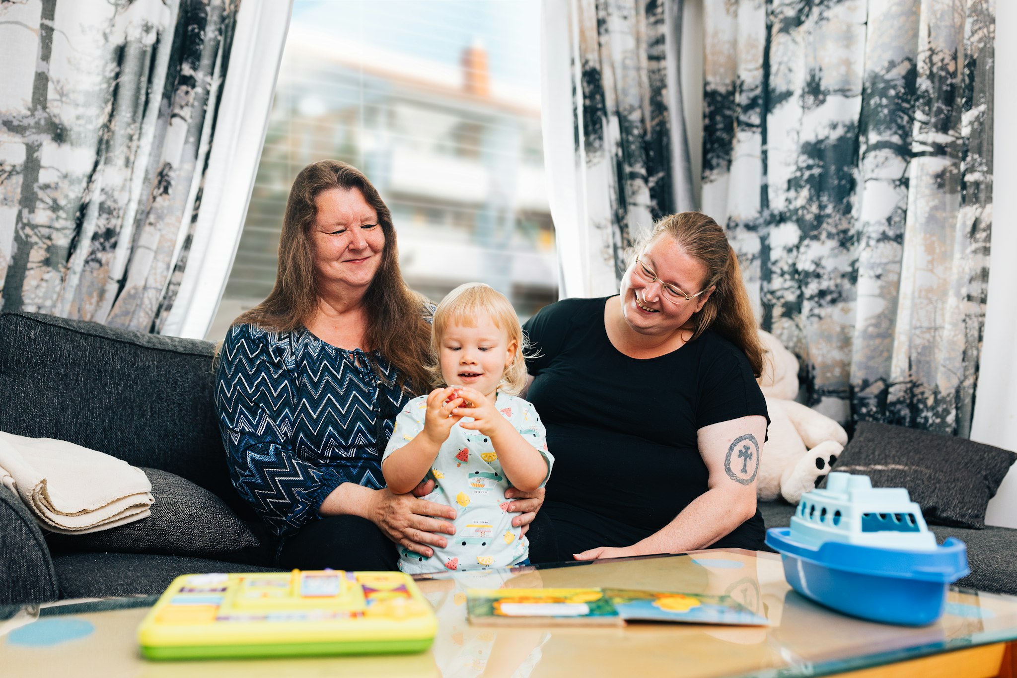 Jenna Tamminen ja Marjatta Koskinen katsovat leikkivää Jiriä.