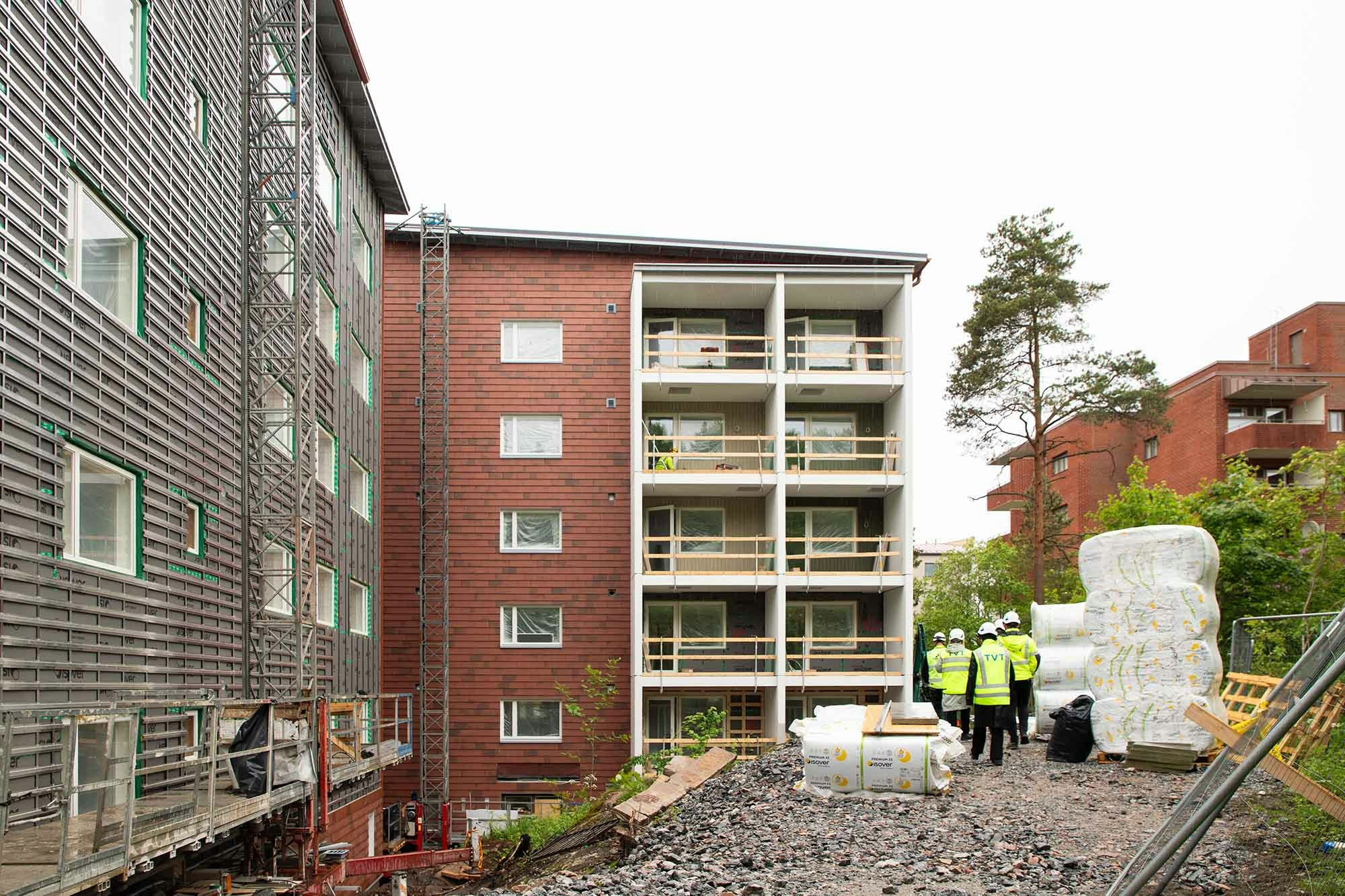 Osittain valmista ulkoseinäpintaa, osittain keskeneräistä sekä vielä rakenteilla olevia parvekkeita.Kousankujan työmaalta.