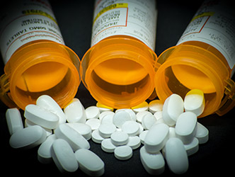 Open pill containers with pills on table