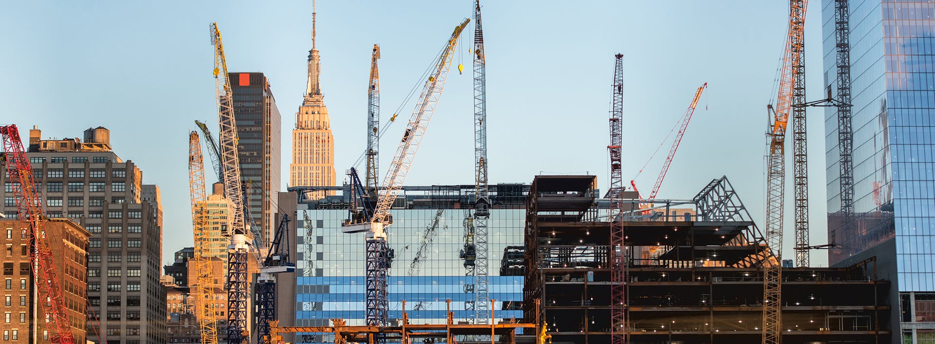 there are many cranes that are in the city and some buildings