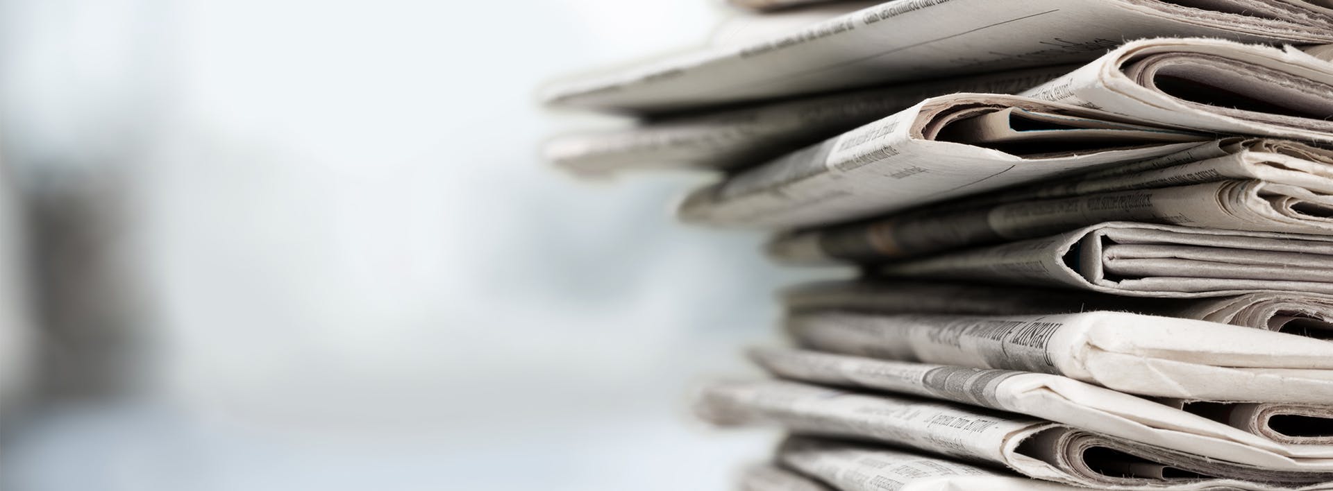 newspapers stacked on top of each other on a table