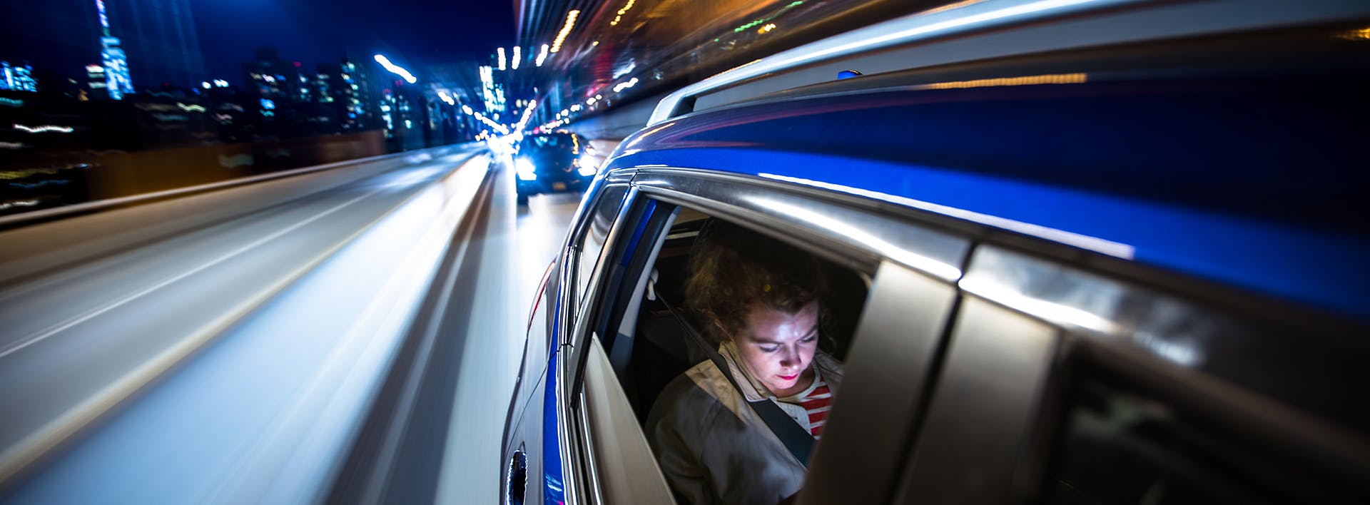 there is a man that is driving in a car at night