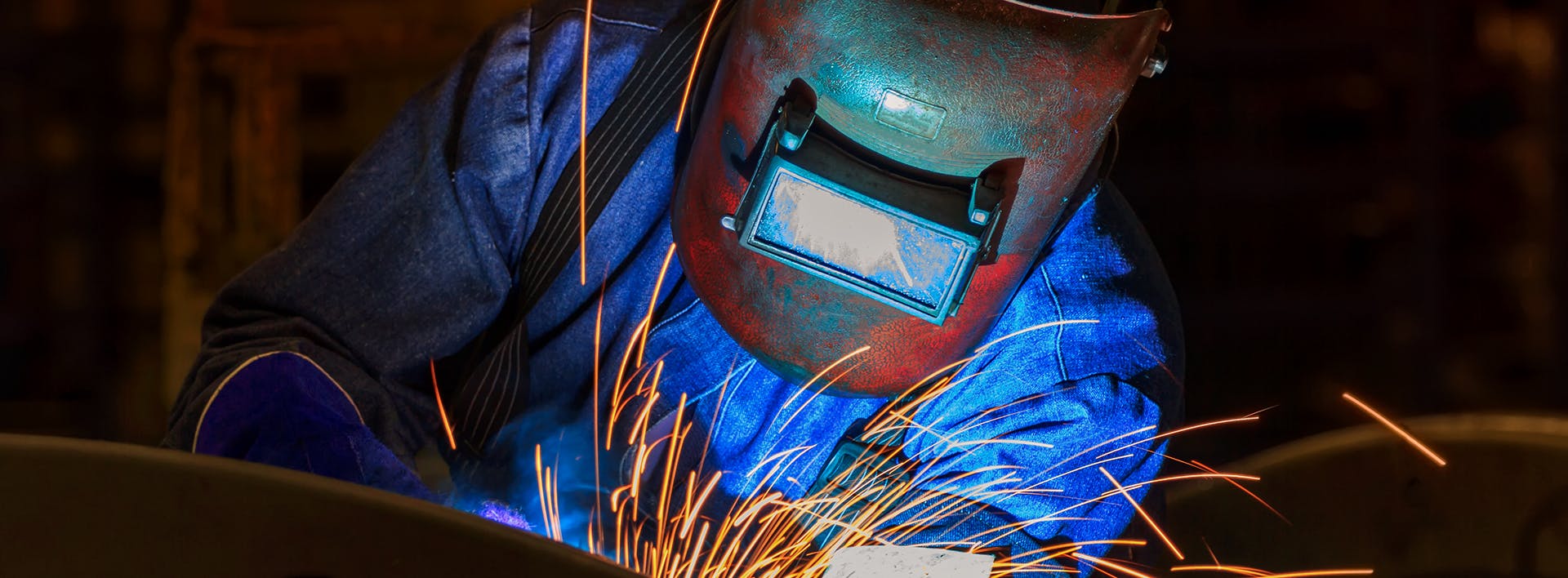 welding a piece of metal with sparks in a dark room