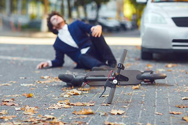 man on the ground next to a scooter
