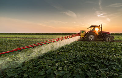 field being sprayed by a tractor