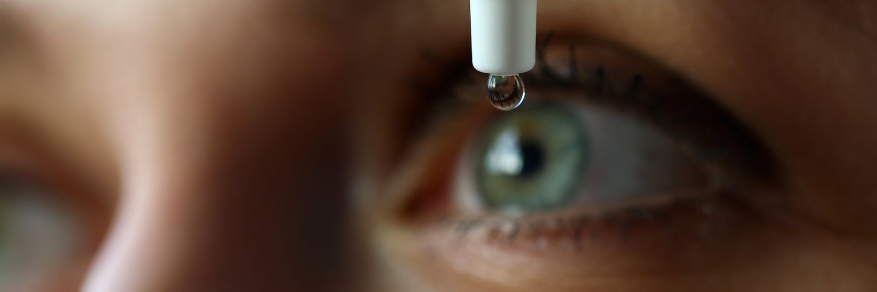there is a close up of a woman's eye with a drop of liquid in it