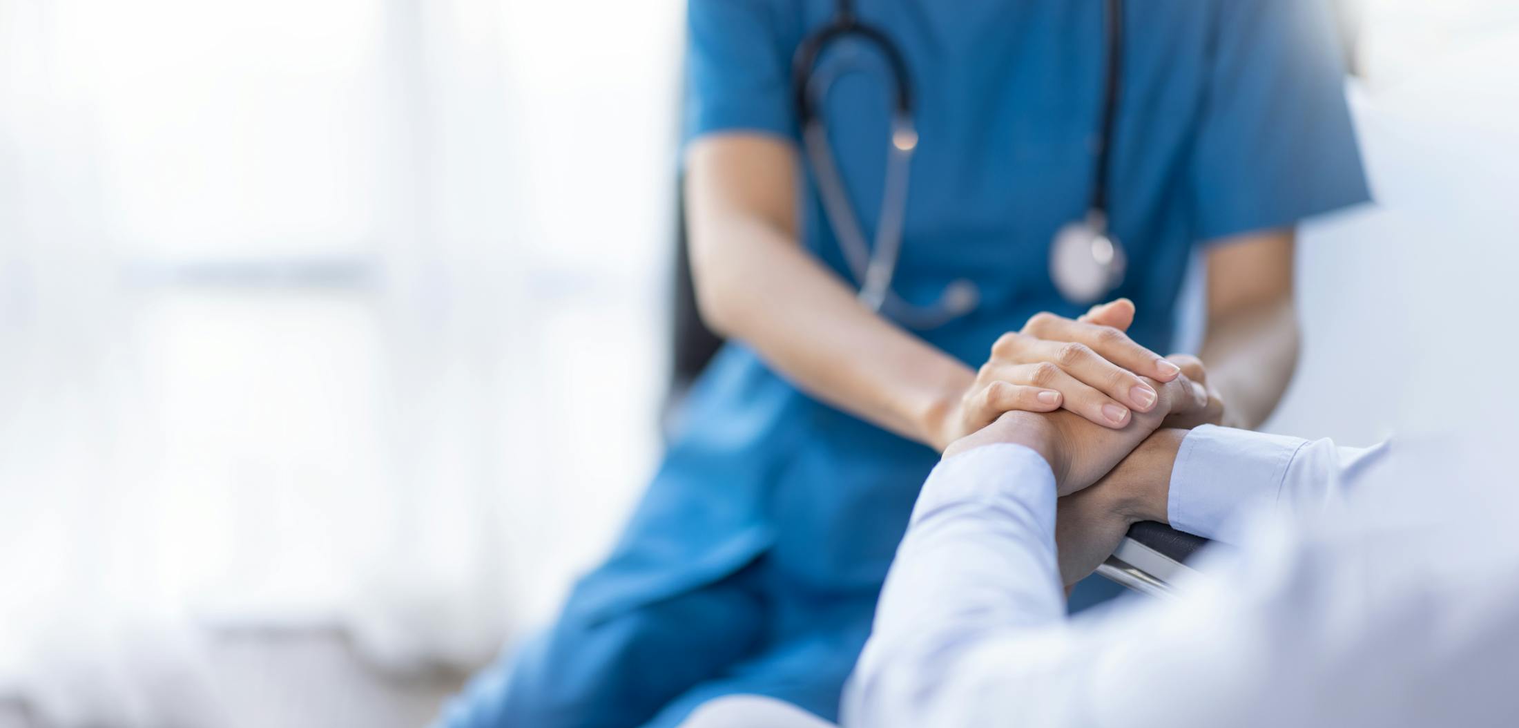 Nurse holding patient's hand