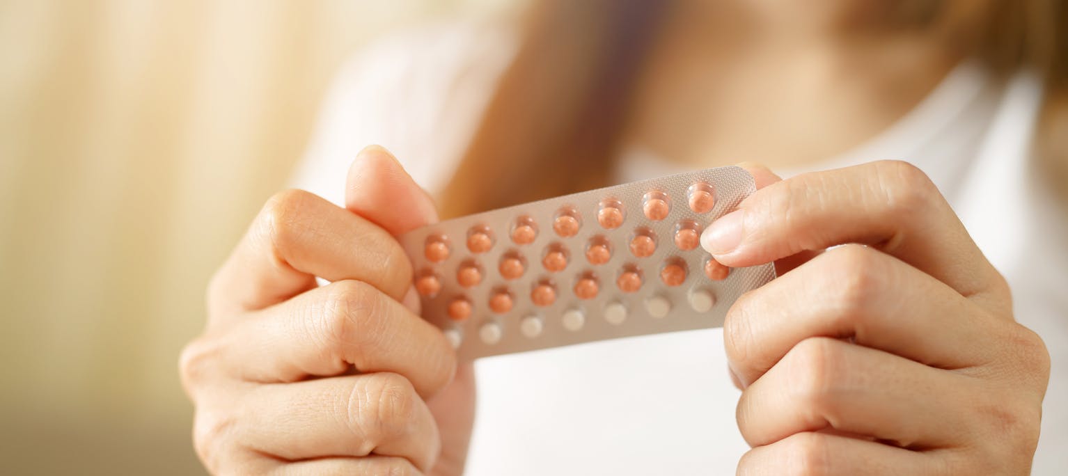 Woman holding a birth control packet