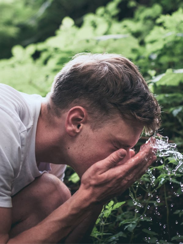 image of a man washing his face with water