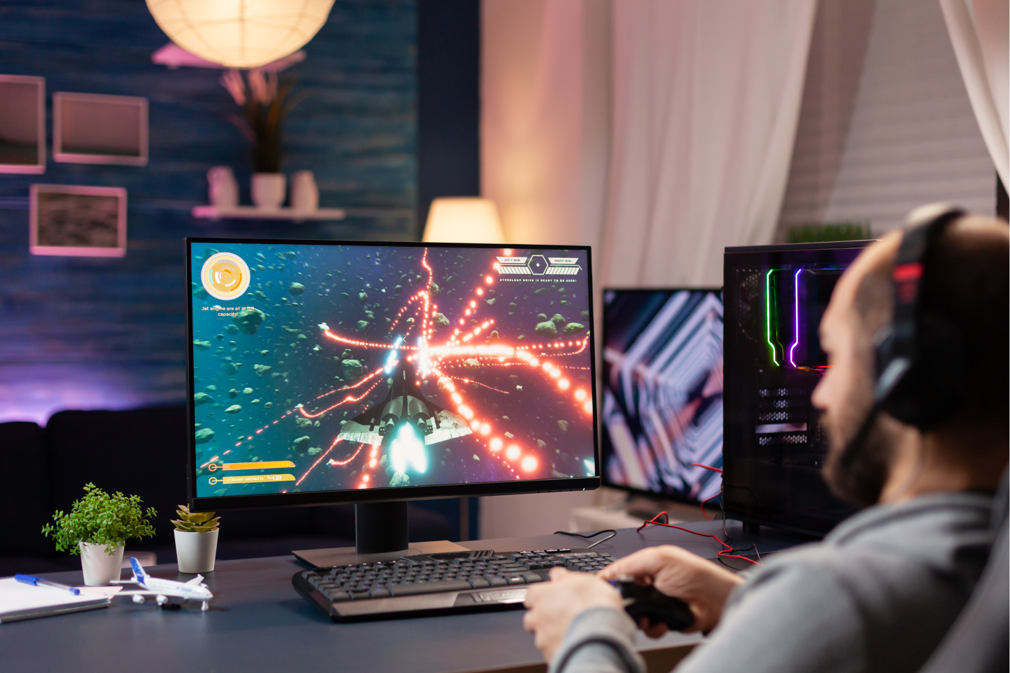 Person playing a space video game on their gaming computer.