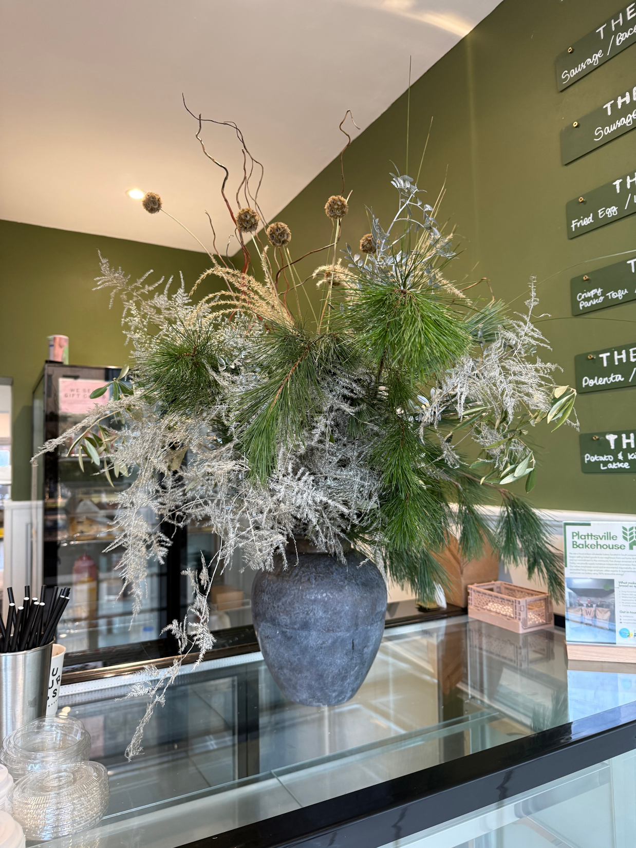 Custom front-of-house festive floral vase arrangement, styled for a commercial reception area as part of a bespoke seasonal installation.