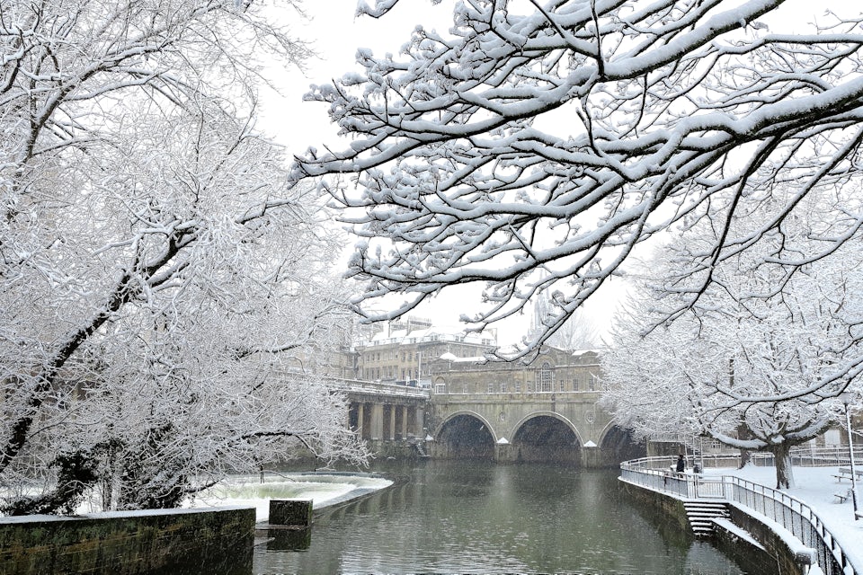 Bath, England a snowy scene showing weir of river Avon and Pulteney Bridge