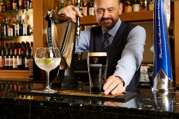 Barman at Hill Valley preparing a gin and a pint of Guinness