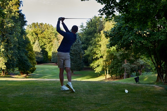 Golfer hitting the ball of the tee