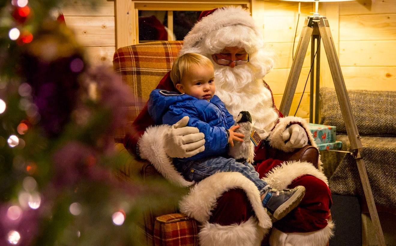 Santa meets a young guest in his Aviemore grotto