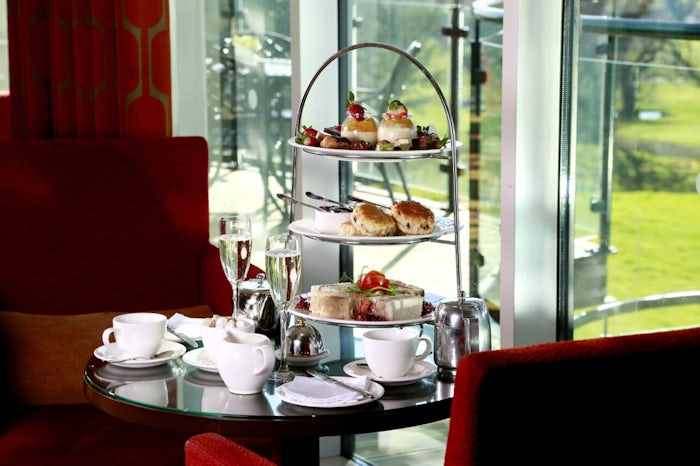 Afternoon Tea at a Macdonald Hotel. A cake stand features fancies, scones, and sandwiches, and the table is set for two.