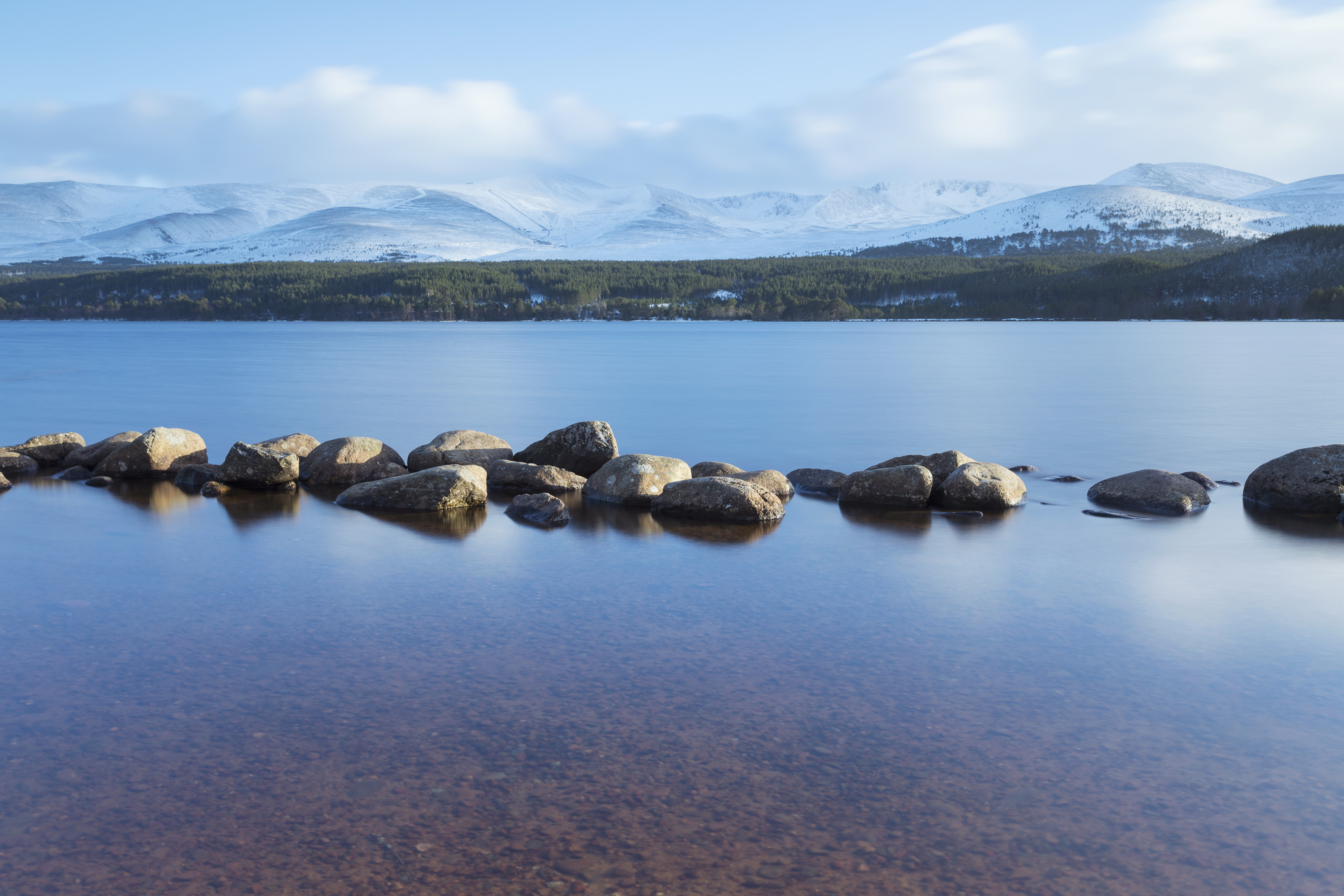 Still lake with snowy mountains in the backgroumd