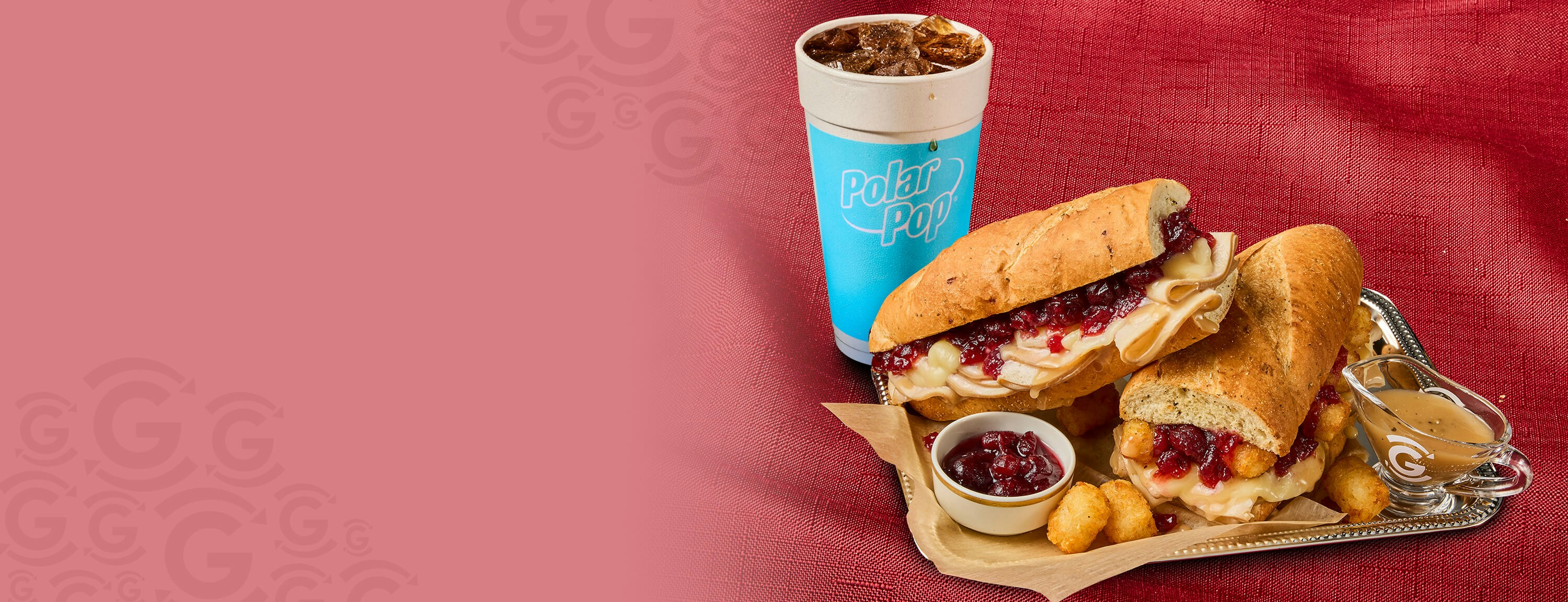 Two turkey and cranberry sandwiches topped with melted cheese and served with tater tots, cranberry sauce, gravy, and a Polar Pop fountain drink.