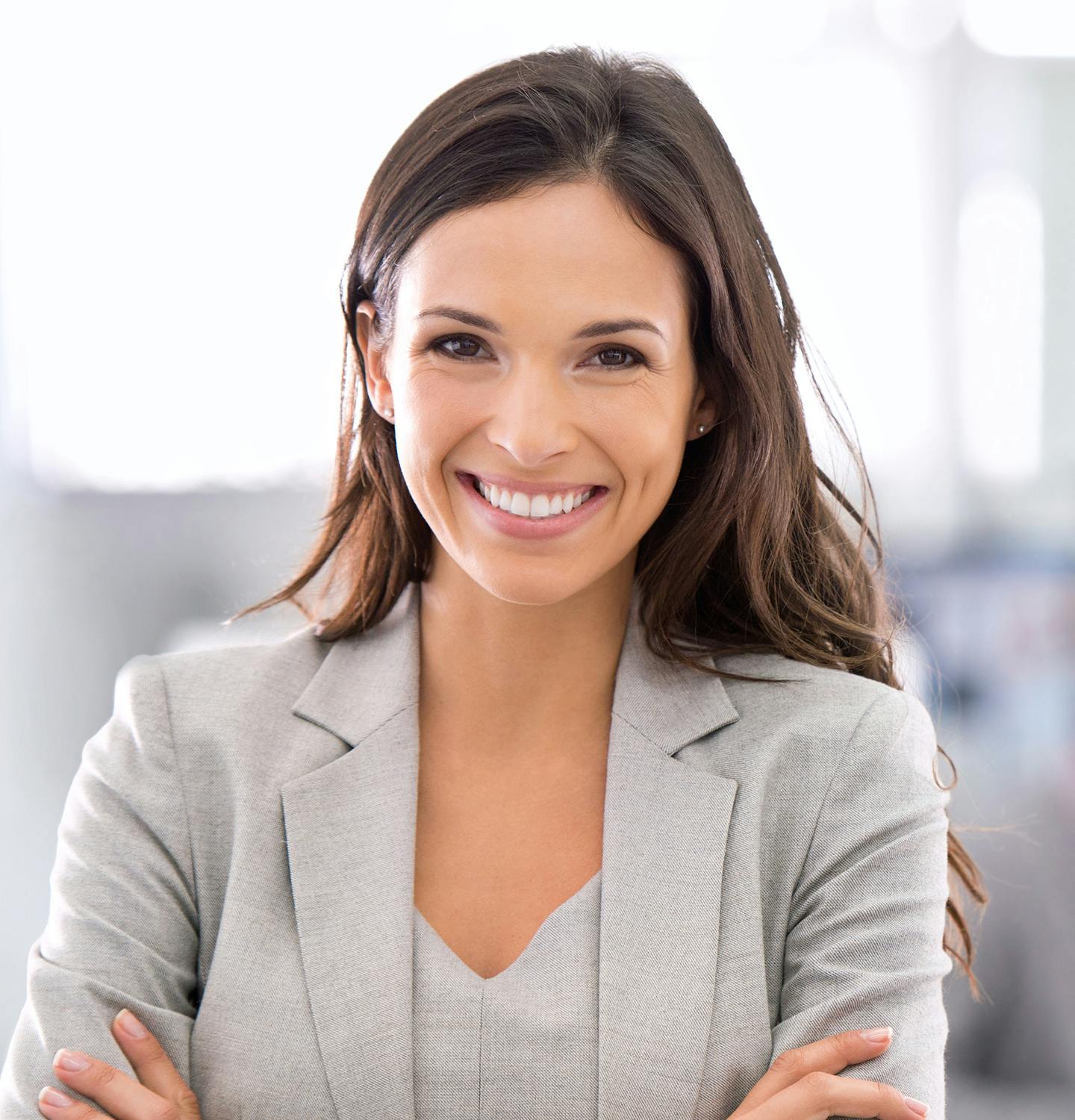smiling woman in business suit with arms crossed in front of her