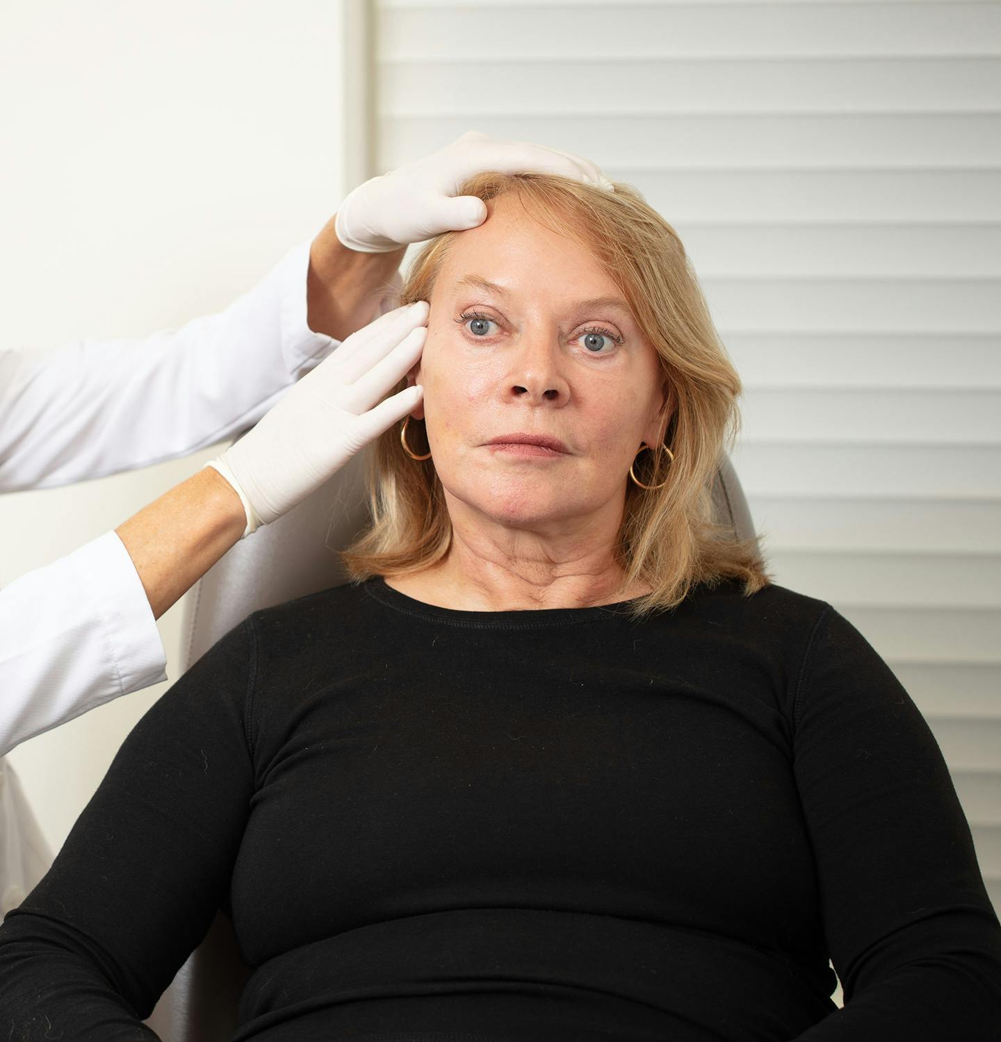 Dr. Jill Hazen examining the side of of a woman't face