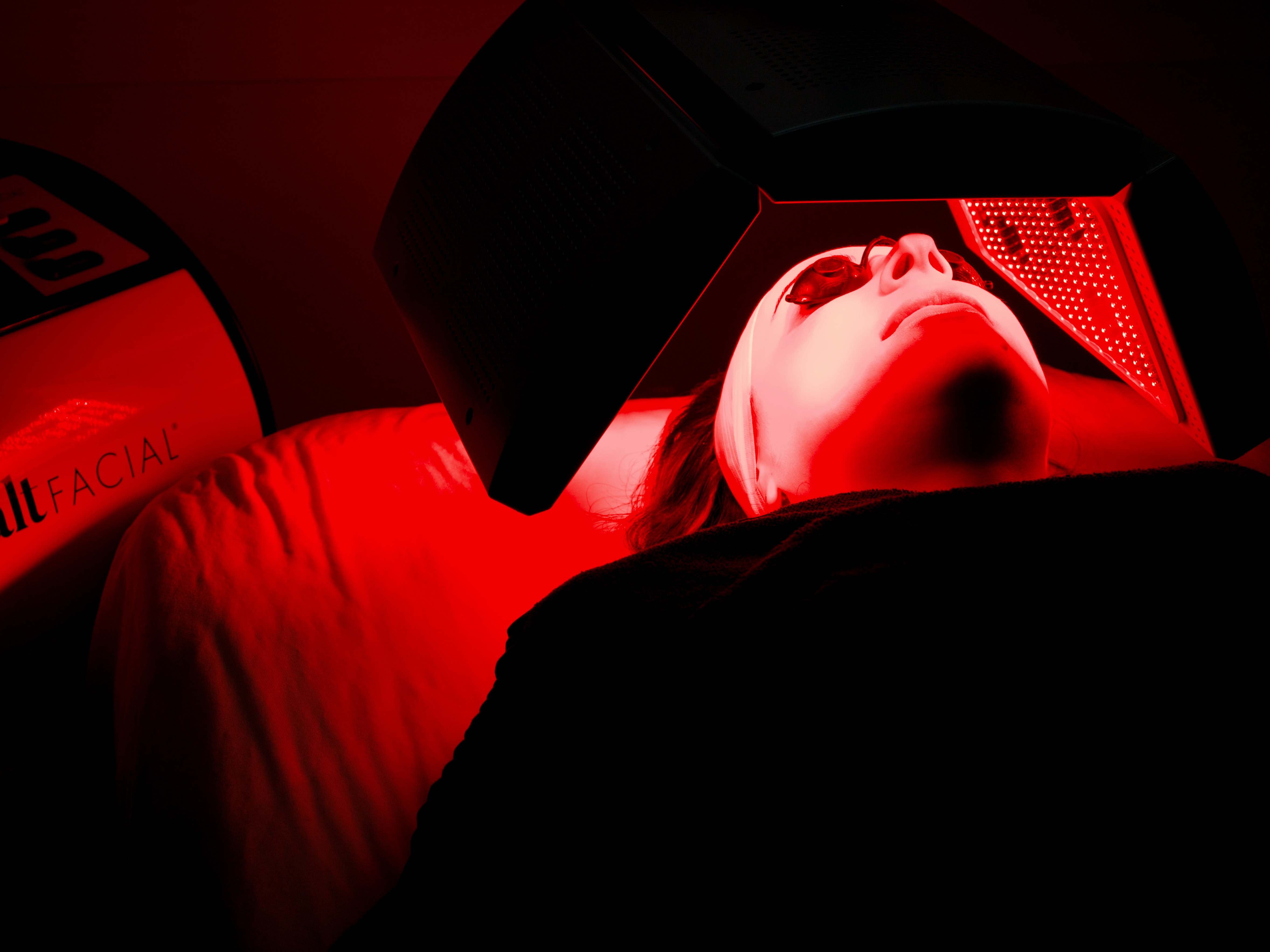 machine being used on woman's face with red light