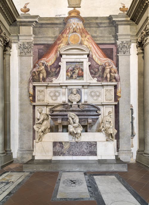 Giorgio Vasari: progetto; Battista Lorenzi: “Busto di Michelangelo”, “Pittura”; Valerio Cioli: “Scultura”; Giovanni Bandini detto Giovanni dell’Opera: “Architettura”; Giovan Battista Naldini: “Pietà e angeli reggicortina”, “Tomba monumentale di Michelangelo Buonarroti”, 1564-1576, marmo e affresco. Firenze, Santa Croce, navata destra