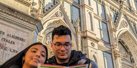 Una giovane coppia legge la mappa dell'atlante dei cammini in Toscana una giovane coppia di fronte a Santa Croce