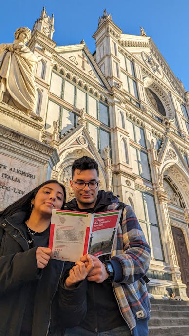 Una giovane coppia legge la mappa dell'atlante dei cammini in Toscana una giovane coppia di fronte a Santa Croce