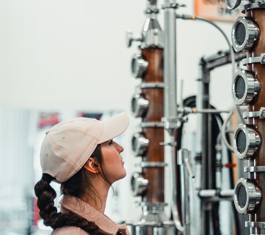 Jeune femme observant un alambic