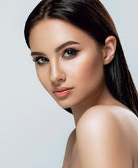 Stunning young woman with sharp eyes and glowing skin.