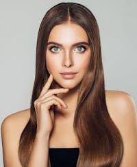 beautiful woman looking at camera with her hands on her chin