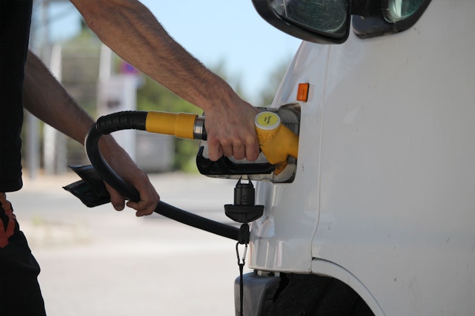 Personne mettant du carbuant dans une camionnette