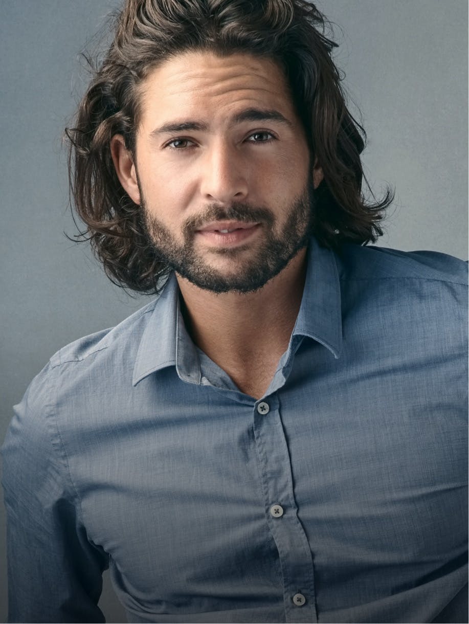 Handsome man with shoulder length dark hair and blue shirt