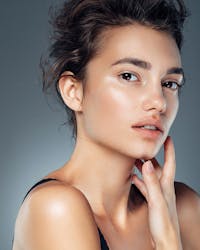 Beautiful woman looking to the side with hand on her lower face