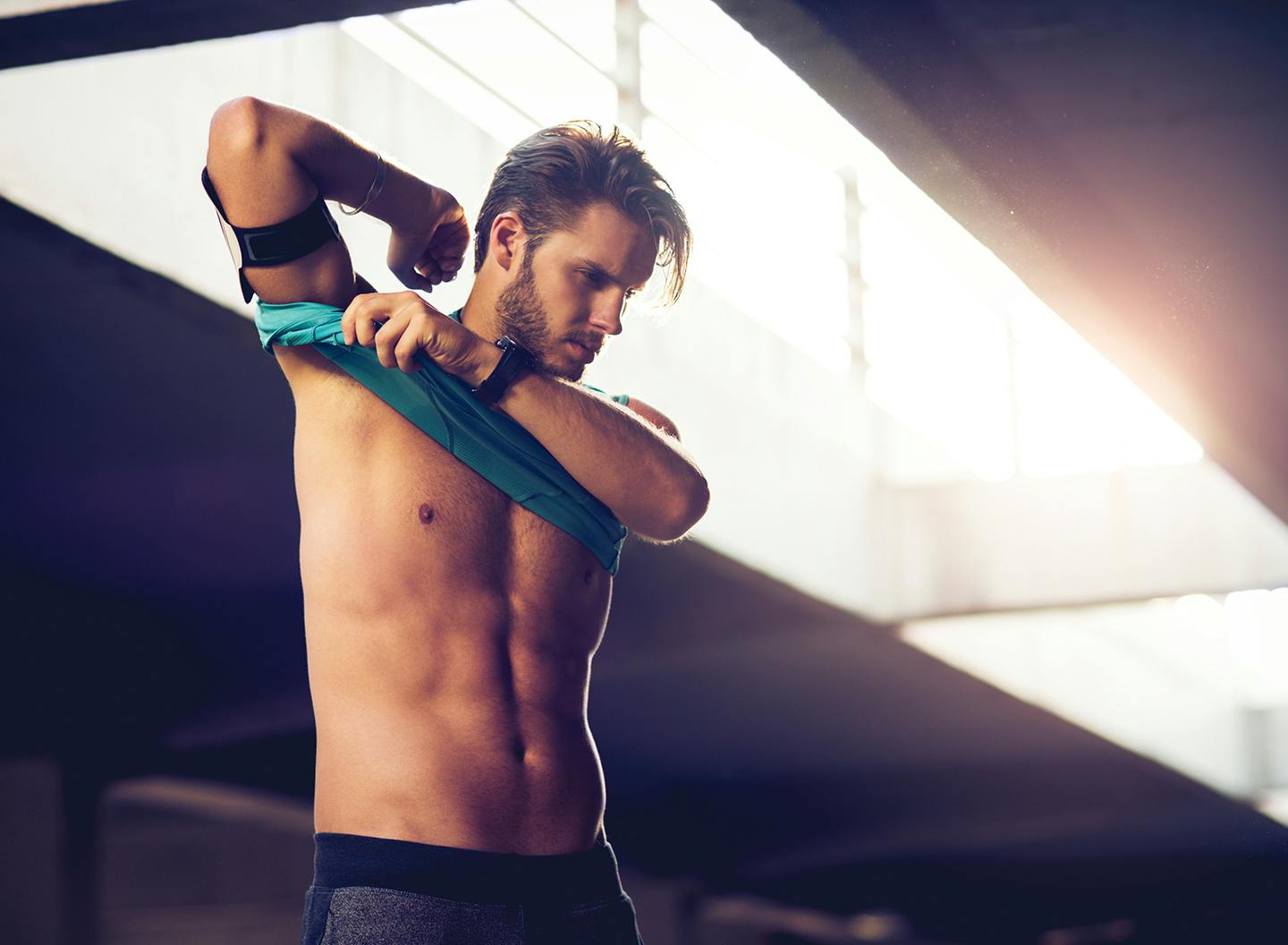 Man taking off shirt at gym