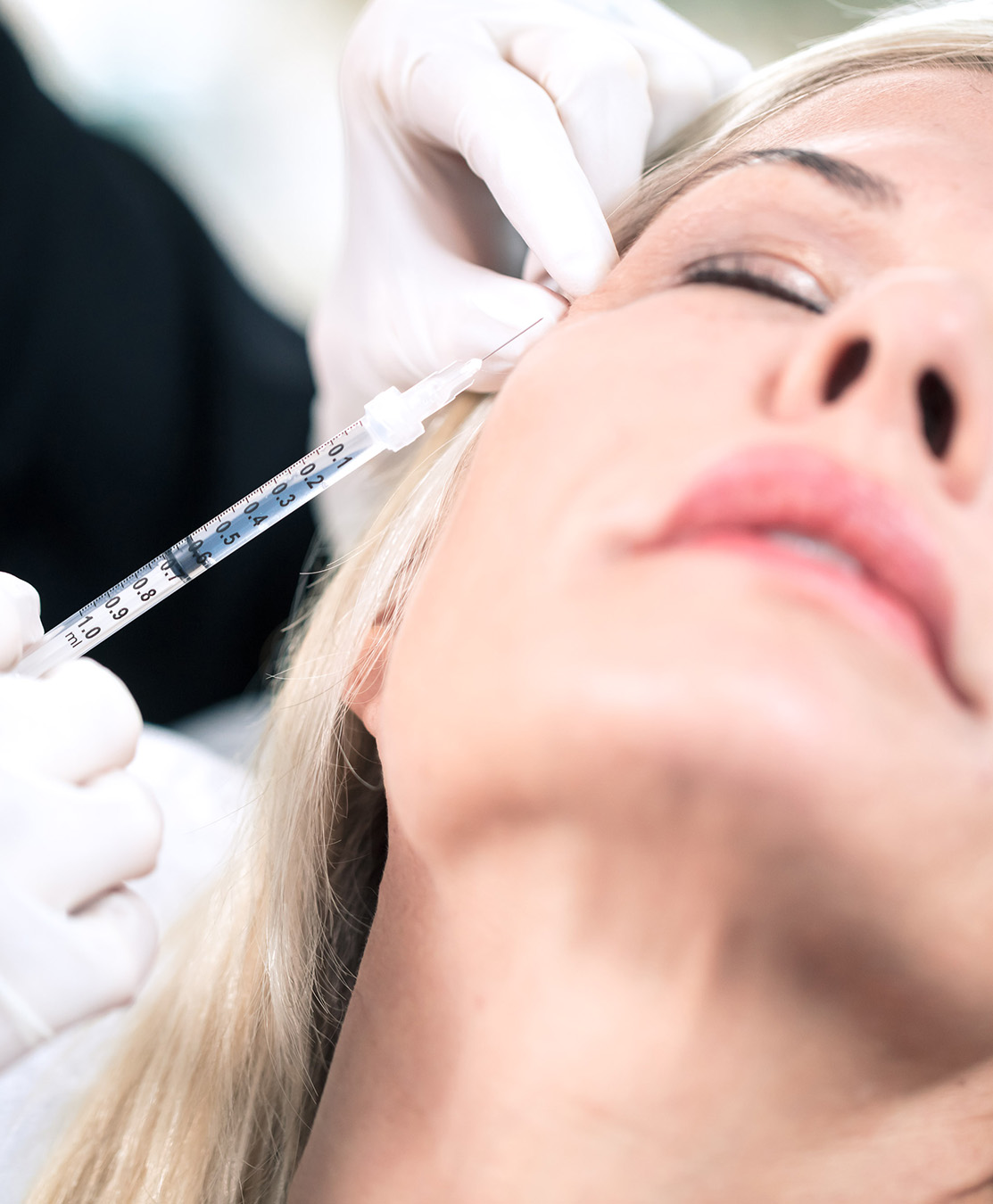 Older woman getting neuromodulators injected in face