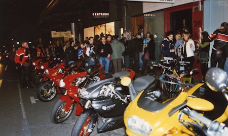 Audiences attend Simone LeAmon, MOTO Showroom, with performance riders from the Moto Guzzi motorcycle club, presented at Gertrude Contemporary Art Spaces, 2003. Courtesy of the artist and the Gertrude Archive.