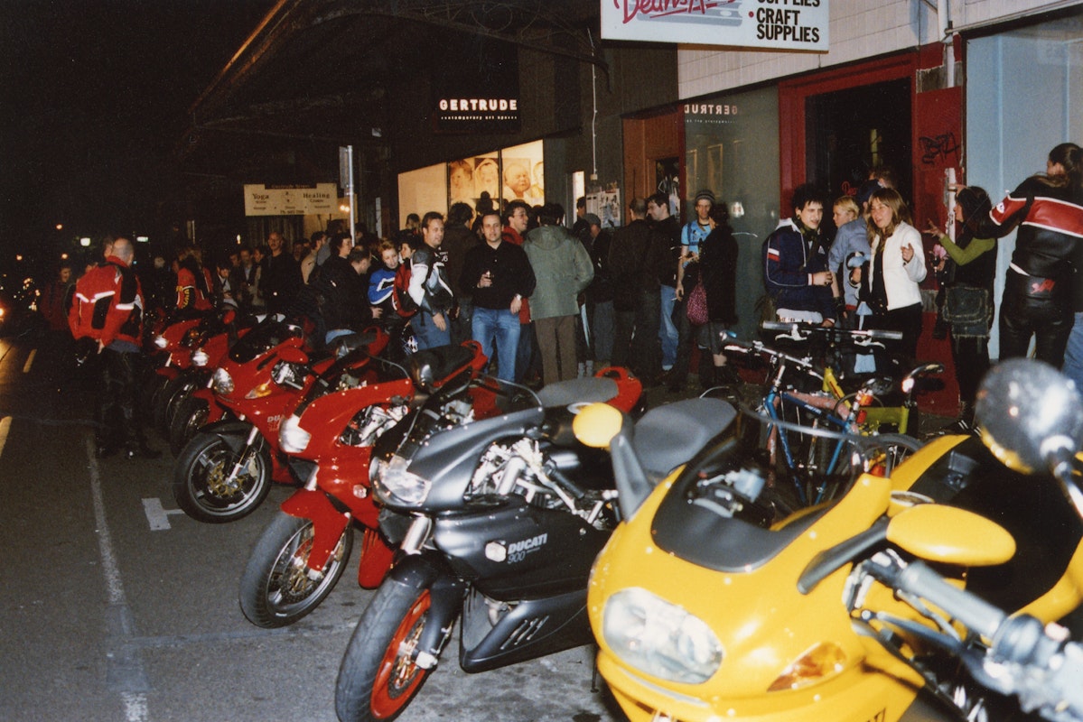 Audiences attend Simone LeAmon, MOTO Showroom, with performance riders from the Moto Guzzi motorcycle club, presented at Gertrude Contemporary Art Spaces, 2003. Courtesy of the artist and the Gertrude Archive.